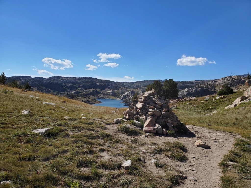 Beaten-Path-109-2020-09-03.Cairn-on-trail-Fizzle-Lake-in-distance